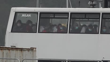 Migrants-wait-in-a-bus-to-be-taken-to-a-processing-centre-in-the-port-of-Dover,-UK