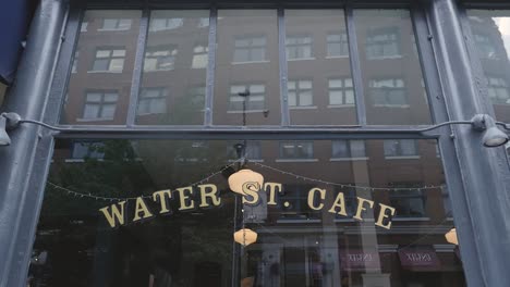 Water-St-Café-Vordereingangsfenster-Weitwinkelschwenk-Nach-Unten-Auf-Schild-An-Einem-Sonnigen-Tag-In-Der-Innenstadt-Von-Vancouver,-BC