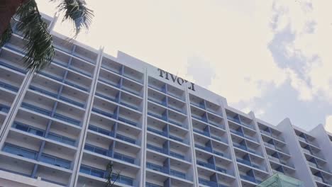 Palm-Tree-In-Front-Of-Iconic-Tivoli-Marina-Hotel,-Luxury-5-star-Hotel-In-Algarve,-Portugal