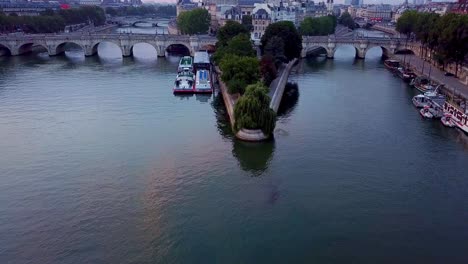 Flying-over-Seine-river-towards-Ile-de-la-Cite,-Notre-Dame-cathedral-and-Pont-Neuf-Bridge-in-Paris,-France