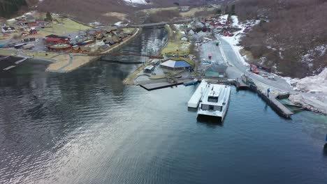 Orbiting-aerial-of-Gudvangen-village-with-electric-passenger-catamaran-Vision-of-the-fjords-alongside-quay-close-to-Gudvangen-hotel
