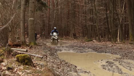 Off-Road-Bike-Splash-Water-Through-Muddy-Forest-Pond,-Close-Up-Dirty-Extreme-Sport-Trial-Speeding-in-Endurance-Adventure-at-Brown-Forest-with-Humid-Wood