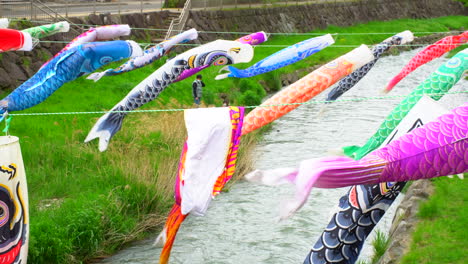 MATSUMOTO,-NAGANO-Circa-2022-May:-A-rainy-spring-day-with-many-colorful-carp-streamers-,-a-Japanese-May-custom,-swimming-pleasantly-in-the-wind-on-the-river