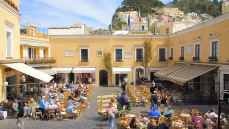 Famosa-Y-Elegante-Plaza-Principal-De-Piazza-Umberto-Llena-De-Gente-Junto-A-Los-Cafés-En-La-Isla-De-Capri,-Campania,-Italia