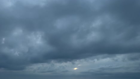 Cockpit-Blick-Von-Einem-Jet-Aus,-Während-Er-Unter-Schichten-Grauer-Und-Dunkler-Stürmischer-Wolken-Fliegt-Und-Die-Sonne-Fast-Verdeckt-Ist
