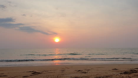 Golden-orange-sunset-over-horizon-in-sandy-beach-of-Thailand