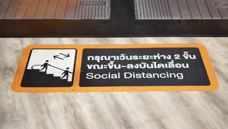 Close-Up-Footage-of-Social-Distancing-Warning-Signboard-on-The-Shopping-Mall-Floor