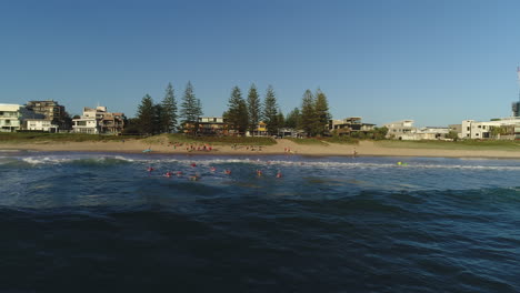 Aerial-view-of-a-group-of-Nippers-paddling-out-into-the-ocean-during-a-morning-training-session-at-Mermaid-Beach-Gold-Coast-Australia