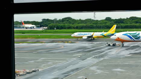 A-Cebu-Pacific-Air-A320-taxies-toward-the-runway-prior-to-takeoff-as-a-widebody-A330-is-towed-to-its-assigned-parking-bay