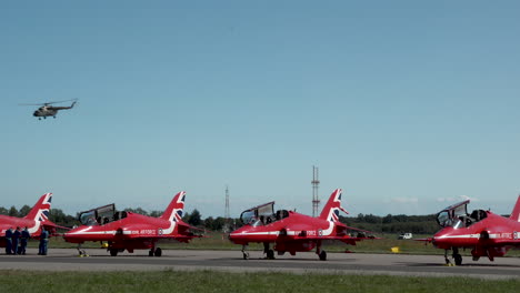 Helicopter-Flying-Over-Fighter-Planes-Of-RAF-Red-Arrows-At-The-Airfield-In-Gdynia,-Poland