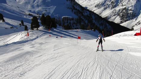 Young-ski-racer-showing-a-downhill-ski-race-start-on-a-steep-race-course