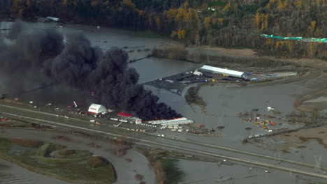 Black-Smoke-Rising-From-RV-Caravan-Burning-In-A-Storage-Yard-After-Rainstorms-Caused-Flooding-In-Abbotsford,-BC,-Canada