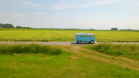Side-on-aerial-view-of-VW-van-driving-through-countryside