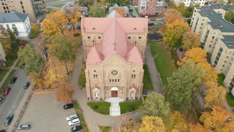 AERIAL:-Church-in-Zverynas-Suburb-in-Vilnius-During-Autumn-on-a-Cloudy-Day-with-Leaves-on-the-Ground