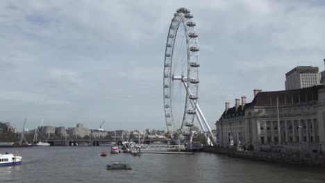 A-scenic-shot-of-the-impressive-London-Eye-Ferris-wheel-from-the-Westminster-Bridge-overlooking-the-river-Thames,-an-iconic-and-popular-tourist-attraction,-London,-England