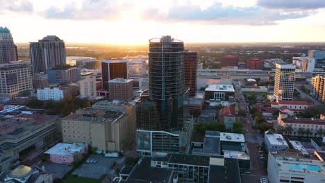 Smooth-and-cinematic-4K-aerial-video-clip-orbiting-around-luxury-high-rises-in-downtown-Orlando,-FL-at-golden-hour