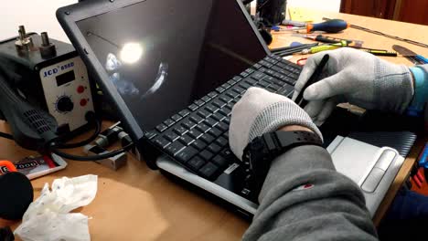 Behandschuhte-Männliche-Hände-Arbeiten-Am-Laptop,-Um-Die-Tastatur-Zu-Ersetzen