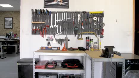 Auf-Steckbrett-Angeordnete-Werkzeuge-In-Einer-Werkstatt-Mit-Büro-Und-Waschmaschine,-Transportwagen-Im-Bild