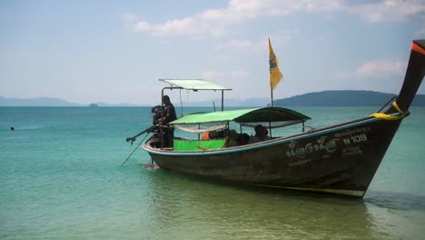 Ein-örtlicher-Thailändischer-Skipper-Lichtet-Den-Anker,-Um-Das-Traditionelle-Thailändische-Boot-Zurückzuziehen-Und-Mit-Den-Touristen-An-Einem-Sonnigen-Tag-In-Thailand-Aufzubrechen