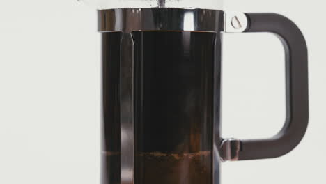 Nahaufnahme-Beim-Langsamen-Herunterdrücken-Des-Deckels-Der-French-Press-Und-Der-Zubereitung-Von-Frisch-Gebrühtem-Kaffee