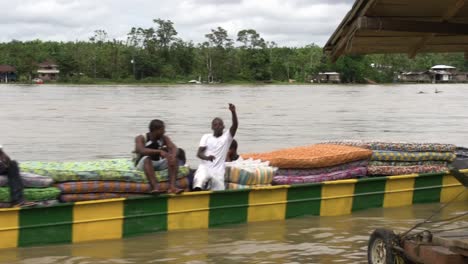A-long-river-boat-with-happy-men-transporting-mattresses-on-a-large-river