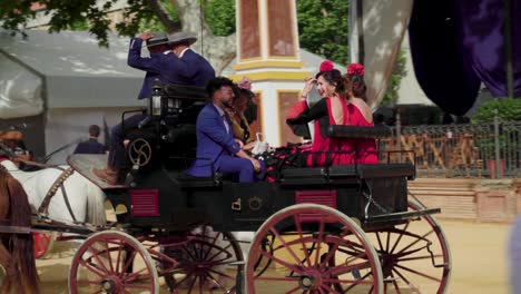 People-in-Flamenco-dresses-and-suits-ride-in-horse-carriage-at-Jerez-fair,-spain