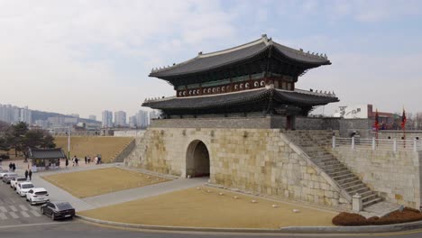 Herencia-De-La-Unesco---Puerta-Norte-De-La-Fortaleza-De-Hwaseong-Con-Pocos-Grupos-De-Visitantes-Y-Autos-Estacionados