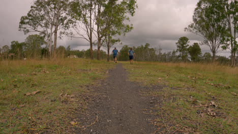 Two-Male-Hikers-walking-from-a-distance,-towards-camera,-along-gravel-pathway,-Brisbane-Valley-Rail-Trail,-Qld-4K