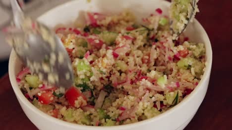 Close-up-of-a-bowl-of-couscous-salad-being-mixed-in-a-bowl