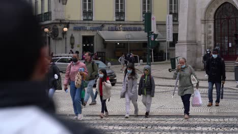People-at-pedestrian-traffic-light-waiting-for-green-light-before-crossing-the-street,-Lisbon,-Portugal