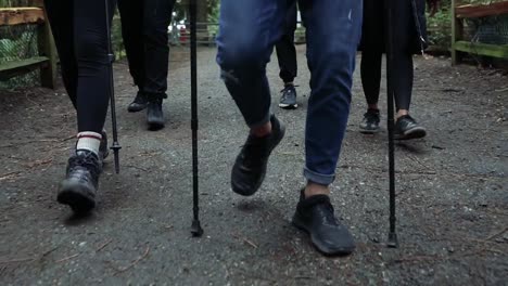 Close-up-shot-of-the-feet-of-a-group-of-hikers,-they-are-walking-close-to-each-other-on-natural-path