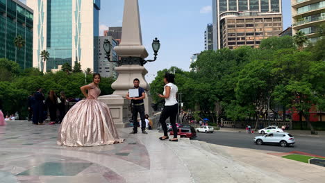 shot-of-quinceanera-taking-a-professional-photo-session-at-angel-de-la-independencia-in-reforma-avenue,-mexico-city