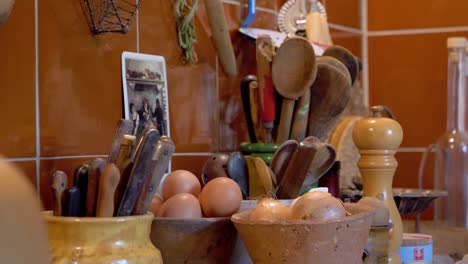 Kitchen-food-preparation-station-at-a-villa-with-eggs,-onions,-spices,-knives-and-utensils,-Dolly-right-close-up-shot