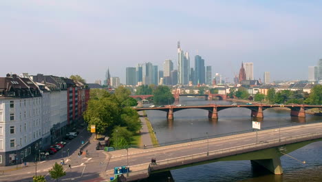 Blick-Auf-Die-Frankfurter-Skyline-Am-Mainufer-Mit-Tagesverkehr-Auf-Straßenbrücken-In-Frankfurt,-Deutschland