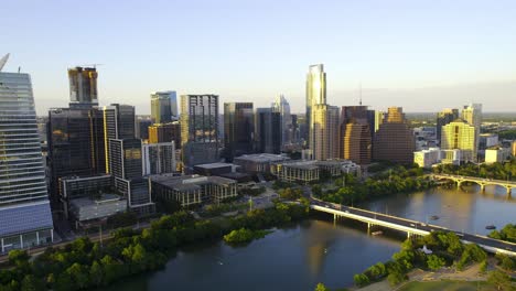 Aerial-view-of-downtown-Austin-and-the-Colorado-river,-warm,-summer-evening-in-Texas,-USA---pan,-drone-shot