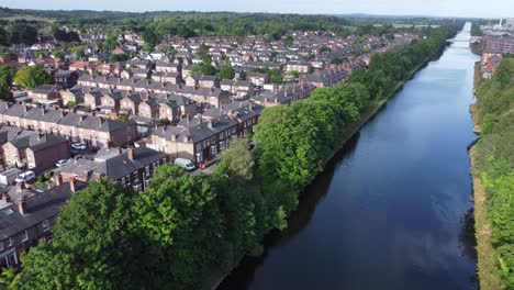 Aerial-view-flying-above-wealthy-Cheshire-housing-estate-alongside-Manchester-ship-canal