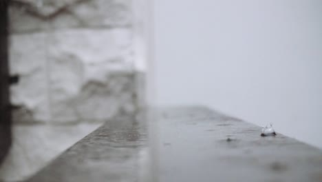 Raindrops-are-falling-down-on-a-flat-surface-in-slow-motion