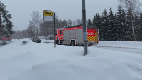 Schwerer-Feuerwehr-Rettungswagen-Schleppt-Durch-Unfall-Beschädigtes-Fahrzeug-Auf-Verschneiter-Straße-Ab