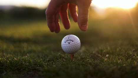 Hand-Teeing-up-Callaway-Golf-Ball-on-Driving-Range-at-Golf-Course,-Close-up