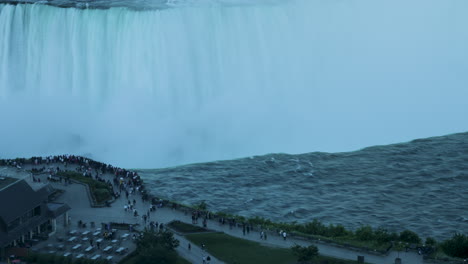 Evening-close-up-timelapse-shot-of-people-gathering-near-the-edge-of-Horseshoe-Falls-in-Niagara-Falls,-Ontario