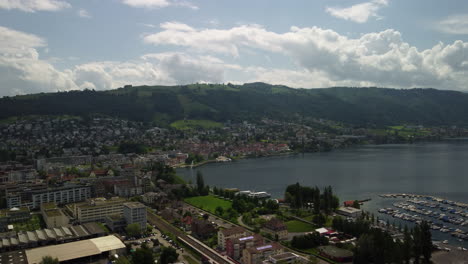 Vuelo-Ascendente-Sobre-La-Ciudad-De-Zug-Y-El-Lago-Zug-En-Suiza