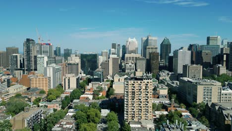 4K-Cinematic-urban-drone-footage-of-an-aerial-view-of-buildings-and-skyscrapers-in-the-middle-of-downtown-Montreal,-Quebec-on-a-sunny-day