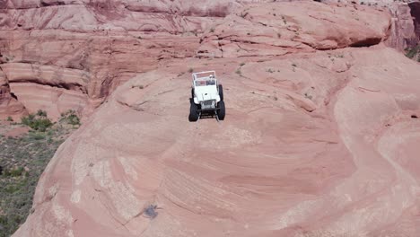 Jeep-Todoterreno-Con-Tracción-En-Las-Cuatro-Ruedas-En-Lo-Alto-De-Un-Acantilado-De-Roca-Roja-En-El-Desierto-De-Moab,-Utah---Antena