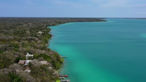 wide-aerial-coastline-of-turquoise-blue-Bacalar-Lagoon-coastline-on-sunny-day-in-Mexico