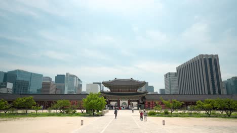 Heungnyemun-Gate-of-Gyeongbokgung-Palace-against-blue-sky-with-skyscrapers-in-background