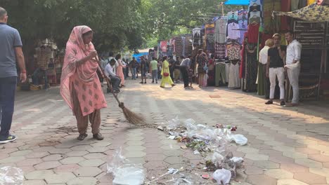A-sanitation-worker-brooms-plastic-handbags-at-a-local-garment-market
