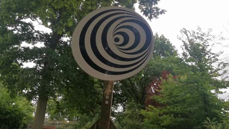 A-Spinning-Spiral-Optical-Illusion-on-a-Wooden-Pole-in-a-Park