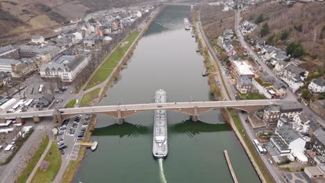 aerial-view-of-a-barge-passing-the-bridge-over-the-river-mosel-in-the-german-city-of-cochem-in-rheinland-palatinate