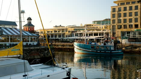 Lokales-Fischerboot-Fährt-Vom-Yachthafen-In-V-Und-Einer-Uferpromenade-In-Kapstadt-Ab
