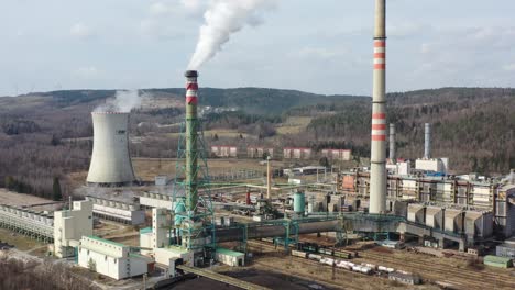 Sokolovska-Uhelna,-Czech-Republic,-Aerial-View-of-Thermal-Power-Plant-Facility,-Smoking-Chimneys-and-Cooling-Tower,-Pull-Back-Drone-Shot